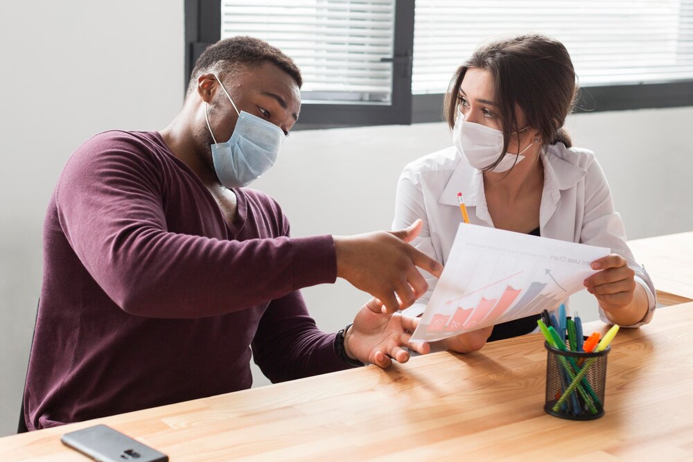 People at work in the office during pandemic with medical masks