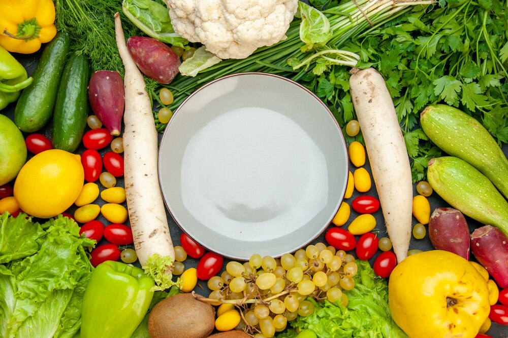 Top view vegetables and fruits cherry tomatoes cumcuat lettuce quince grape lemon cauliflower white radish parsley zucchini plate in center